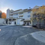 Exterior of JJ's Lodge four-story condominium building showing main entrance to units 861 through 886