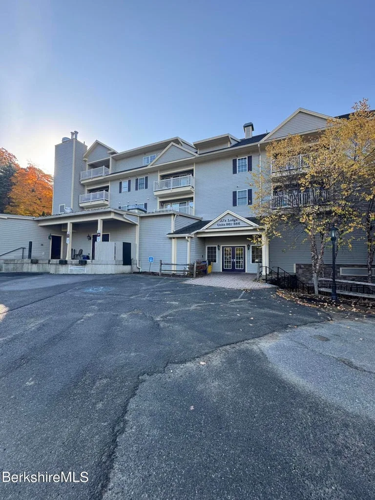 Exterior of JJ's Lodge four-story condominium building showing main entrance to units 861 through 886