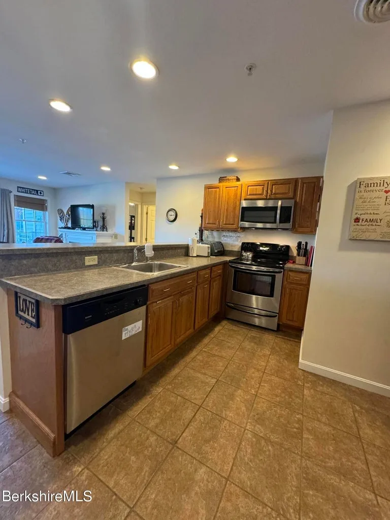 Kitchen with oak cabinets, breakfast bar, stainless range, microwave, and dishwasher at JJ's Lodge 862